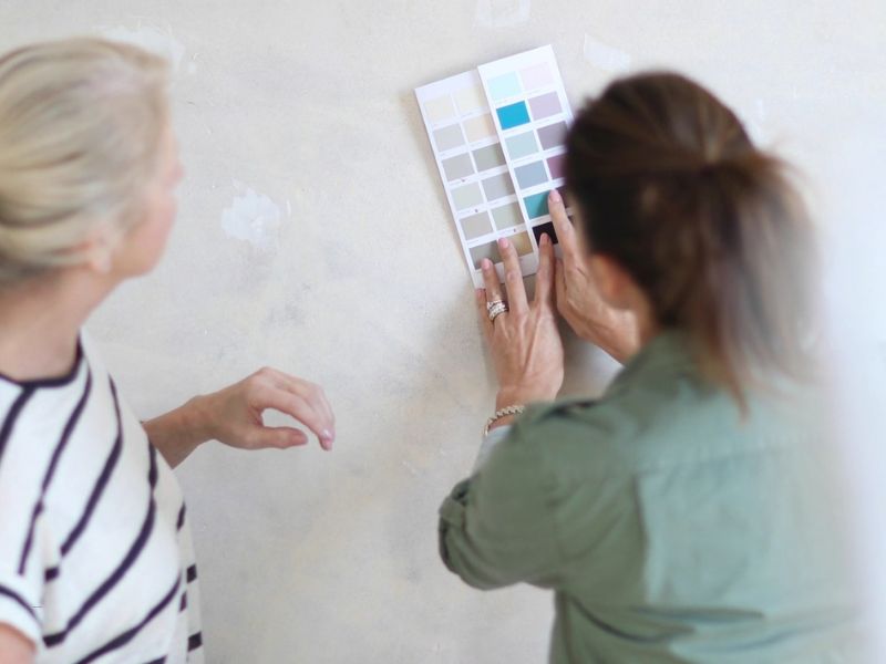 dve osobe biraju boju za zid koristeći katalog sa nijansama