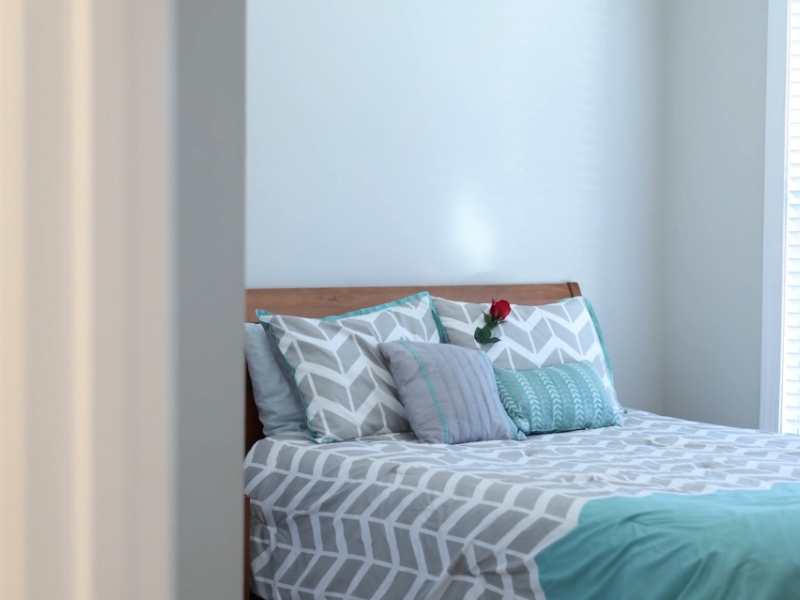 Krevet uz zid sa šarenom posteljinom u spavaćoj sobi